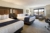 Hotel room with two beds, a couch and a desk